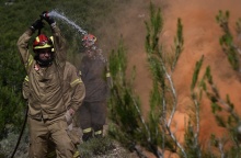 Πυροσβέστης με μάνικα κατά τη διάρκεια κατάσβεσης φωτιάς