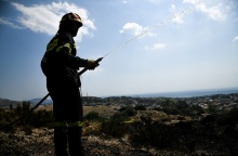 Πυροσβέστης με μάνικα ανά χείρας κατά τη διάρκεια κατάσβεσης