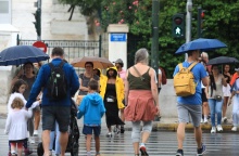 Πολίτες στο κέντρο της Αθήνας κρατούν ομπρέλα για να προστατευτούν από τη βροχή