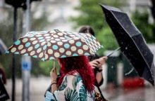 Πολίτες με ομπρέλα εν μέσω βροχής στο κέντρο της Αθήνας