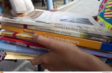 Σχολικά βιβλία στα χέρια μαθητή