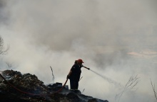 Γυναίκα πυροσβέστης επιχειρεί με τη μάνικα για την κατάσβεση φωτιάς