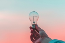 Λάμπα την οποία κρατά ένα χέρι ψηλά με φόντο τον ορίζοντα