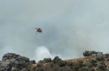 Καπνοί και πυροσβεστικό ελικόπτερο που επιχειρεί στη φωτιά στο Ρέθυμνο