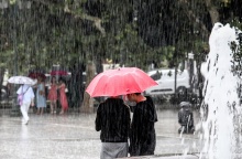 Πολίτες με ομπρέλα προστατεύονται από τη βροχή