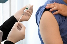 Άτομο επιχειρεί να κάνει εμβόλιο σε άτομο που έχει σηκώσει το μανίκι του