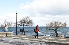 Άτομο περπατά δίπλα στη θάλασσα εν μέσω κρύου με μπουφάν και σκουφί