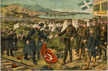 Επιχρωματισμένο χαρακτικό το οποίο αποδίδει τη στιγμή της παράδοσης της Θεσσαλονίκης από τον Ταχσίν Πασά στον Αρχιστράτηγο και Διάδοχο Κωνσταντίνο. Η παράδοση έγινε τις τελευταίες μέρες του Οκτωβρίου 1912, στο πλαίσιο του Α´ Βαλκανικού Πολέμου. Εικονίζονται πολλά σημαίνοντα πρόσωπα του στρατιωτικού βίου της χώρας. Από τις Συλλογές του Πολεμικού Μουσείου 