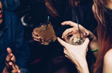 Άτομα σε κλαμπ κρατούν τα ποτήρια με το ποτό τους