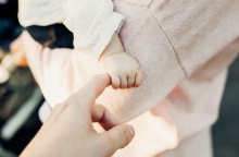 Άτομο κρατά το χεράκι μωρού