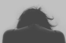 Γυναίκα με σκυμμένο κεφάλι υποδηλώνοντας πως έχει δεχτεί επίθεση