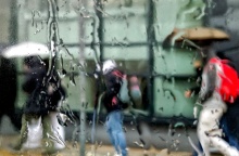 Πολίτες με ομπρέλα προστατεύονται από τη βροχή