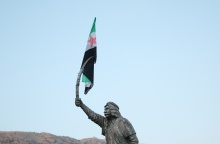 Η σημαία της συριακής αντιπολίτευσης κρέμεται από το ξίφος του αγάλματος του Δρούζου Σουλτάνου Αλ-Ατράς Πασάατ 