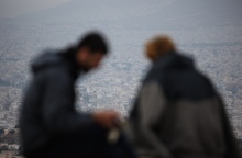 Δύο άτομο με φόντο τη συννεφιασμένη Αθήνα