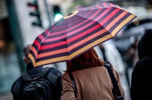 Γυναίκα με ομπρέλα προστατεύεται από τη βροχή