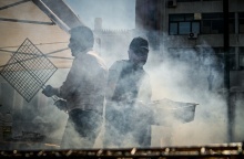 Τσίκνα από ψήσιμο και δύο άνθρωποι που ψήνουν