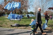 Παιδί με ελληνική σημαία και σταντ με σημαίες