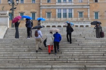 Πολίτες με ομπρέλες εν μέσω βροχής