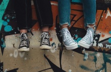 Παπούτσια νέων που κάθονται στο πεζούλι