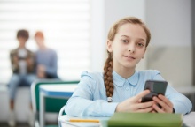 Νεαρή μαθήτρια με το κινητό ανά χείρας