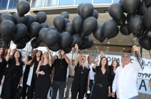 Συγγενείς θυμάτων και εγκαυματιών κρατούν μαύρα μπαλόνια έξω από το Εφετείο Αθηνών 