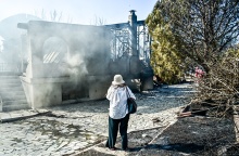 Γυναίκα μπροστά από καμένο σπίτι στην Παλαιά Φώκαια