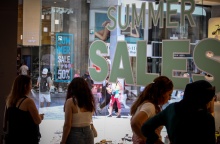 Πολίτες κοιτούν βιτρίνες με εκπτωτικές προσφορές