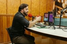 Άτομο σε στούντιο μπροστά από δύο μικρόφωνα