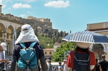 Πολίτες με καπέλα εν μέσω καύσωνα στο κέντρο της Αθήνας