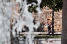 Άτομο δίπλα σε συντριβάνι υπό συνθήκες καύσωνα