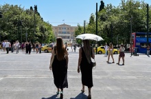 Γυναίκες με ομπρέλες προστατεύονται από τον ήλιο εν μέσω καύσωνα