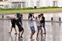 Πολίτες περπατούν εν μέσω βροχής