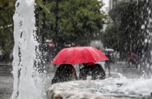 Πολίτες κρατούν ομπρέλα εν μέσω κακοκαιρίας