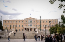 Πολίτες στην πλατεία Συντάγματος με φόντο τη Βουλή