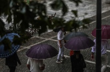 Πολίτες με ομπρέλες εν μέσω βροχής