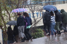 Πολίτες με ομπρέλες εν μέσω βροχής