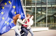 Νεαρά κορίτσια που κρατούν τρέχοντας τη σημαίατης ΕΕ