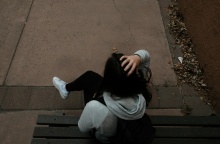 Ανήλικη καθισμένη σε παγκάκι με την πλάτη γυρισμένη στον φακό