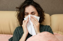 Άτομο σκουπίζει τη μύτη του με χαρτομάντηλα