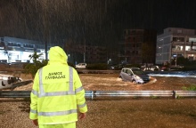 Υπάλληλος του δήμου Γλυφάδα σε σημείο δρόμου που έχει μετατραπεί σε ποτάμι