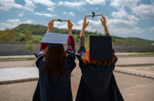 Νεαρές γυναίκες με τίβενο κρατούν στα χέρια τους το πτυχίο τους 