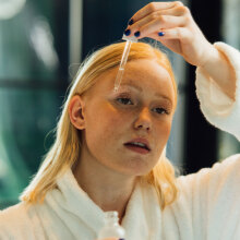 Κοπέλα που βάζει σέρουμ στο πρόσωπό της