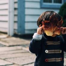 Μικρό παιδί που έχει βάλει ένα φύλλο μπροστά στο πρόσωπό του