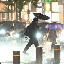 Πολίτες εν μέσω κακοκαιρίας περπατούν σε δρόμο της Αθήνας