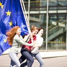 Νεαρά κορίτσια που κρατούν τρέχοντας τη σημαίατης ΕΕ