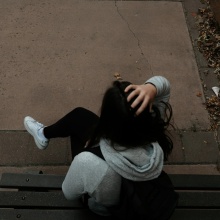 Ανήλικη καθισμένη σε παγκάκι με την πλάτη γυρισμένη στον φακό