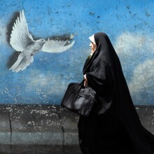 Γυναίκα στην Τεχεράνη, την πρωτεύουσα του Ιράν, περνά μπροστά από mural που δείχνει ένα περιστέρι να πετά