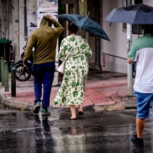 Πολίτες με ομπρέλα εν μέσω καταιγίδας