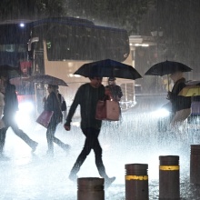 Πολίτες περπατούν στον δρόμο, μπροστά από οχήματα εν μέσω κακοκαιρίας - καταιγίδας