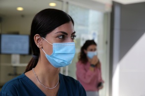 Γυναίκα φορά μάσκα προστασίας από τον κορωνοϊό σε εσωτερικό χώρο